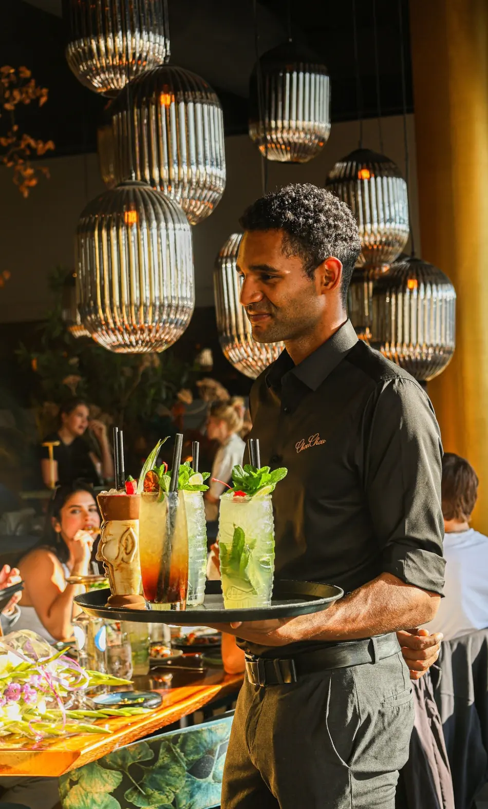 Een medewerker serveert cocktails bij ChouChou